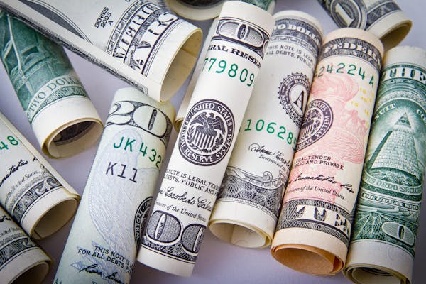 Close-up of rolled US dollar bills symbolizing wealth, financial success, and currency.