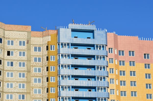 Vibrant multi-colored apartment building exteriors under a clear blue sky.